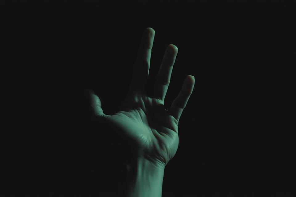 A hand reaching from darkness